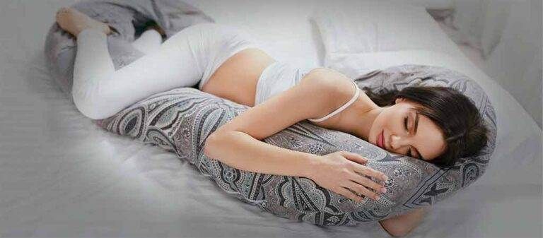 A woman sleeping on a large body pillow