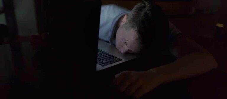Man sleeps with a laptop at night