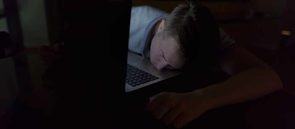Man sleeps with a laptop at night