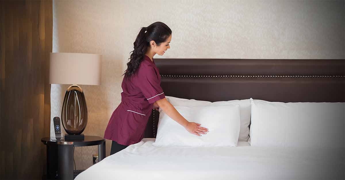 Hotel maid fixing extra pillows. Do hotels charge for extra pillows?